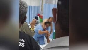 A imagem mostra um momento de tensão em que uma enfermeira que era mantida refém por um paciente em surto, consegue se desvencilhar