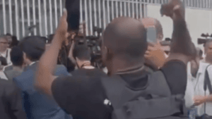 Homem fazendo protesto na entrevista de Bolsonaro (Foto: Reprodução)